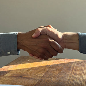 Apretón de manos sobre una mesa de madera