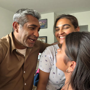 Hombre riendo de cerca con sus hijas, sin guardar distancia