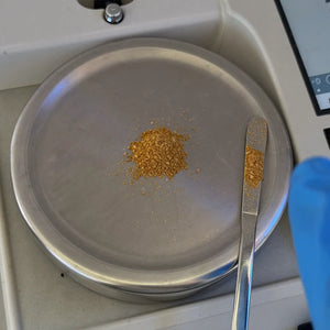 Polvo de extracto de ajo pesado sobre el platillo de una balanza de laboratorio